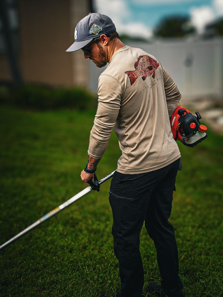 Crew member edging the lawn with a string trimmer